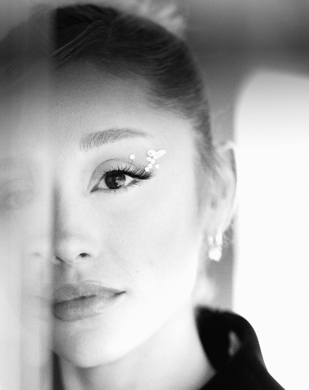 Striking close-up portrait of an adult woman with glitter eye makeup, set against a blurred background, emphasizing beauty and detail.