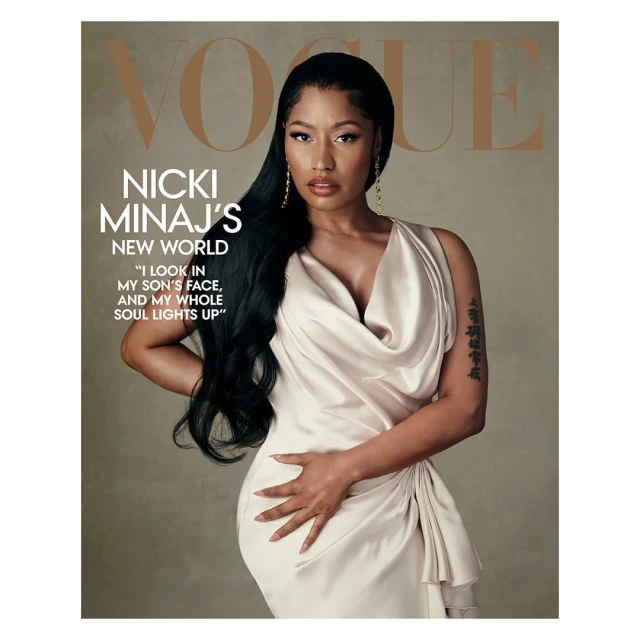 Nicki Minaj graces the cover of Vogue, posing in a draped gown with long black hair and statement earrings against a neutral backdrop.