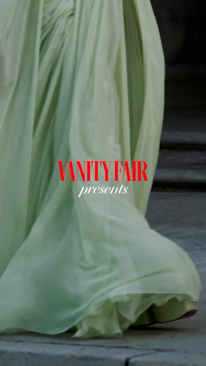 Chiffon gown by Vanity Fair cascades down steps in a fashion shoot. The light green dress and textured steps are in soft focus.