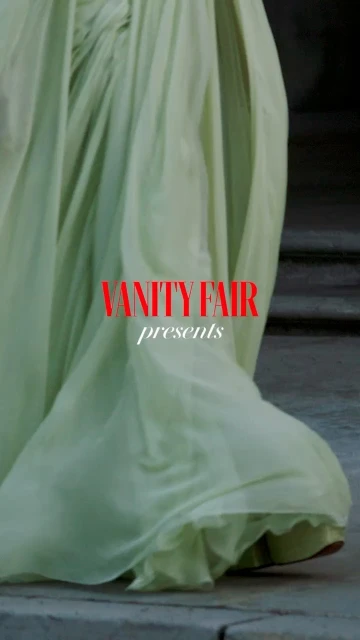 Chiffon gown by Vanity Fair cascades down steps in a fashion shoot. The light green dress and textured steps are in soft focus.