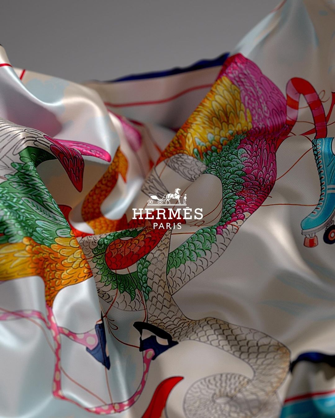 Close-up of a silk scarf featuring an abstract bird and roller skates design, with the Hermes Paris logo in the center.