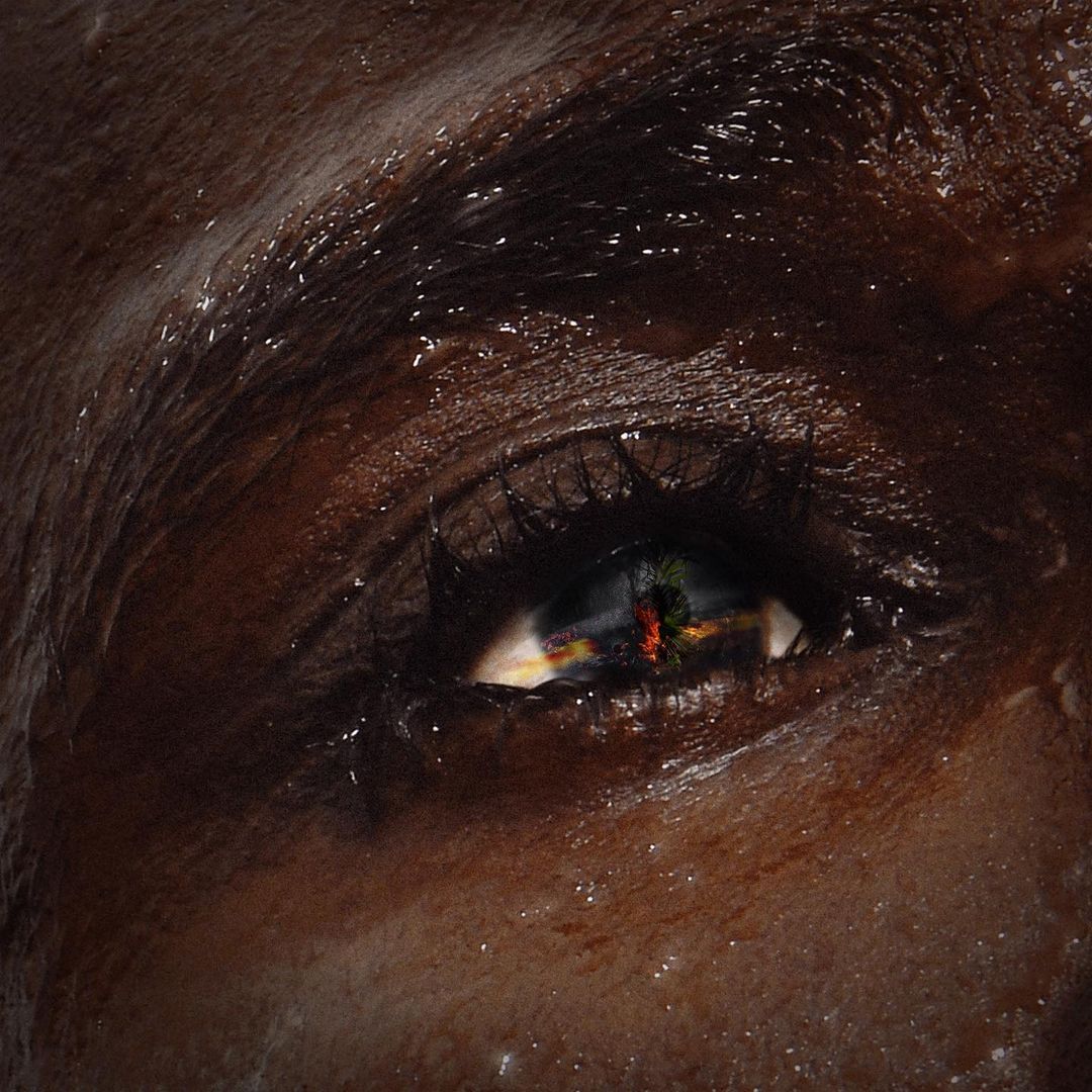Close-up studio shot of a dark-skinned person's eye, showcasing detailed skin texture and eye reflection; artistic, beauty, and portraiture.