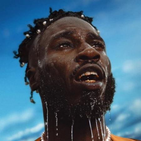 Close-up portrait of a Black man with water dripping down his face against a bright blue sky background.