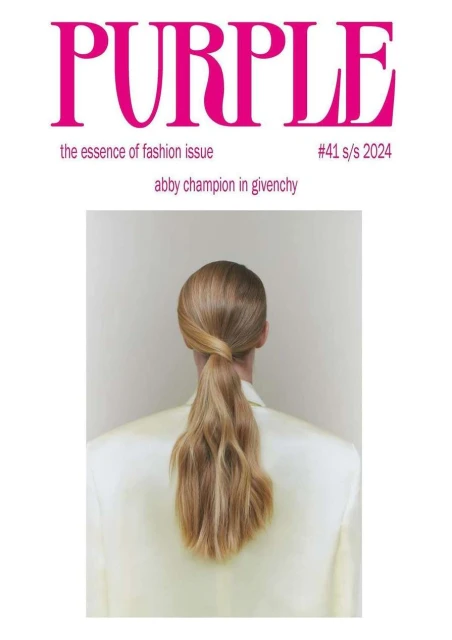 Fashion magazine cover features a blonde woman with a ponytail, seen from behind, wearing a cream-colored jacket against a neutral background.