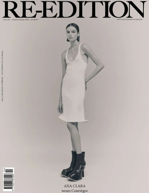 Magazine cover featuring a model in a white dress and black boots against a neutral backdrop, promoting fashion and editorial style.