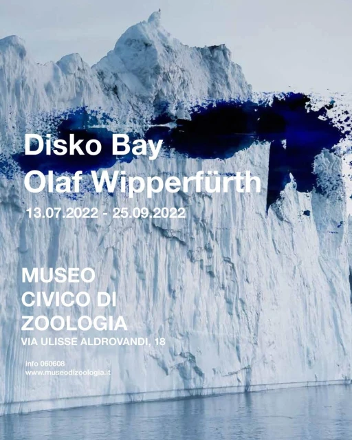 Scenic iceberg landscape under blue sky, evoking a sense of arctic wilderness. Advertisement text in white font for Disko Bay.