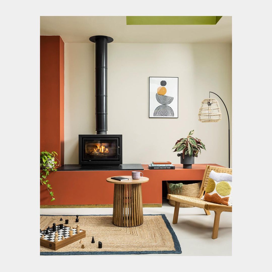 Living room interior with a modern fireplace, wooden furniture, a chess board, and neutral color scheme creating a cozy atmosphere.
