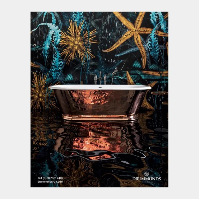 Stunning copper bathtub with intricate surface, set against a backdrop of an aquatic themed wallpaper with golden accents.