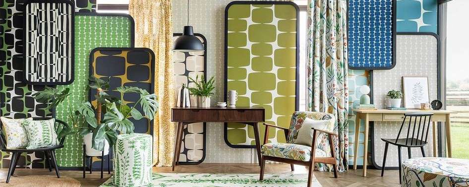 Retro interior design featuring patterned screens, a wooden console table with plants, and chairs with floral upholstery. Interior design.
