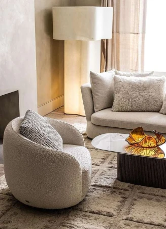 Modern living room interior with a cream boucle armchair, a matching sofa, and a sculptural floor lamp by Oli Douglas
