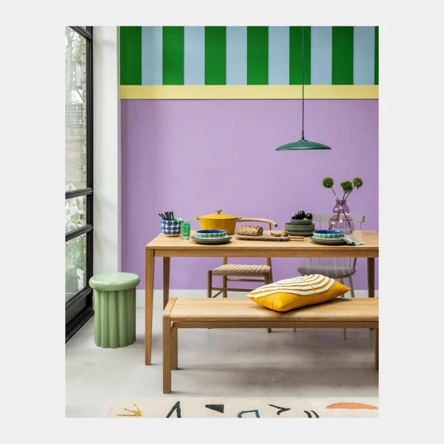 Dining room interior with a wooden table set, colorful wall art, and stylish décor. A serene and inviting space.