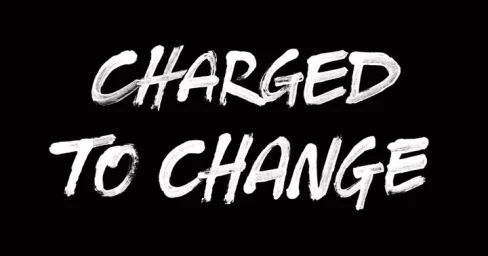 Hand-painted white brushstroke typography reading CHARGED TO CHANGE centered against a solid black background.