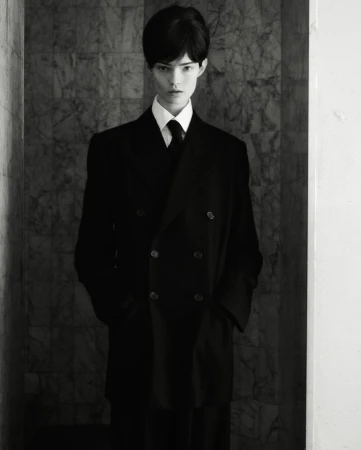 Model in black double breasted coat and tie photographed by Oliver Hadlee Pearch in New York
