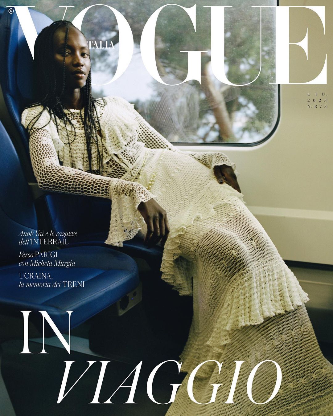 Vogue Italia cover featuring a Black woman in a white lace dress, seated on a train, with large white Vogue logo at the top.