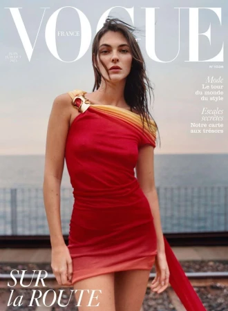 Vogue France magazine cover featuring a woman in a red dress with a gradient hemline, standing on train tracks, against a sky backdrop.