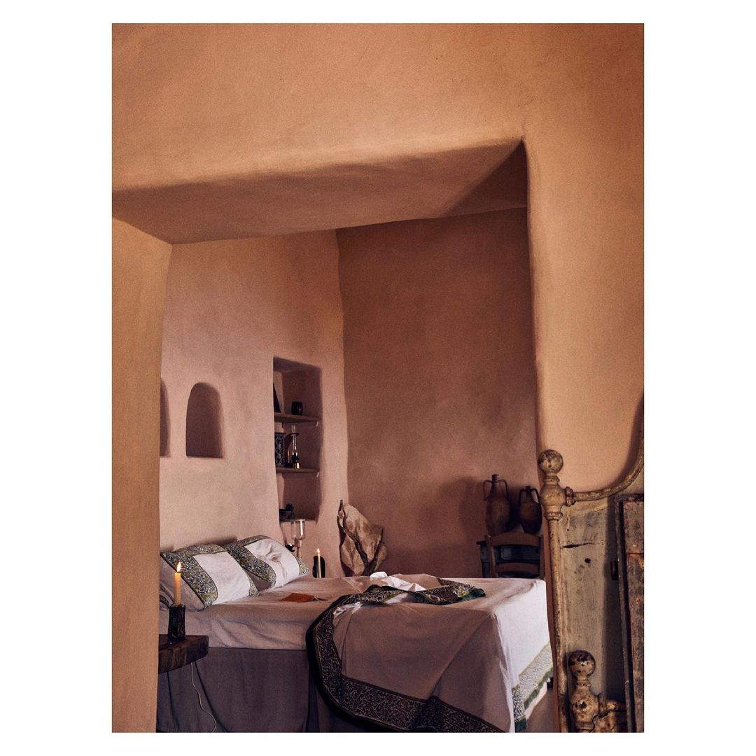Warm-toned bedroom interior featuring a made bed, earthy walls, and subtle lighting creating a cozy and inviting atmosphere.