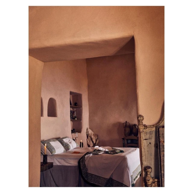 Warm-toned bedroom interior featuring a made bed, earthy walls, and subtle lighting creating a cozy and inviting atmosphere.