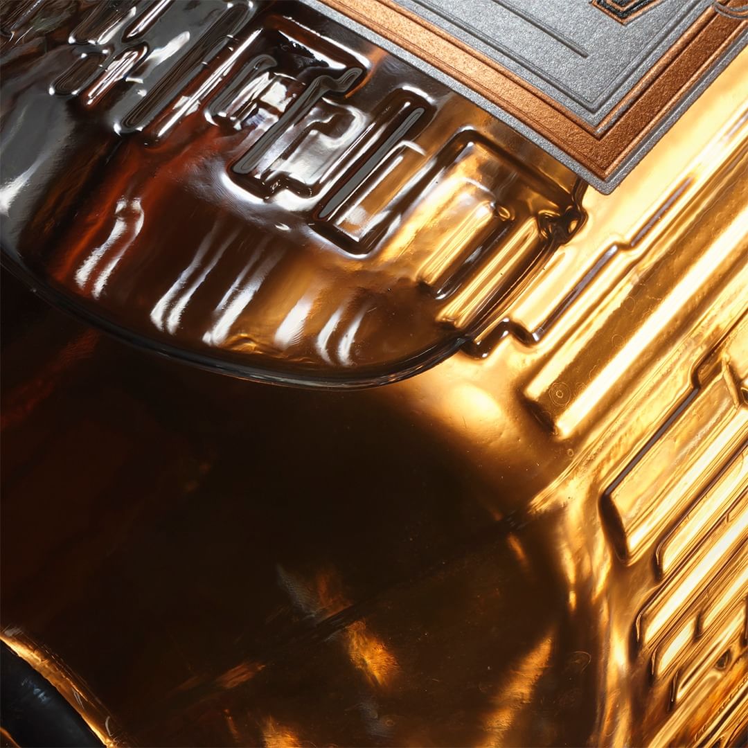 Abstract close-up of a metallic surface with geometric patterns in bronze, silver, and copper tones creating a textured, modern design.