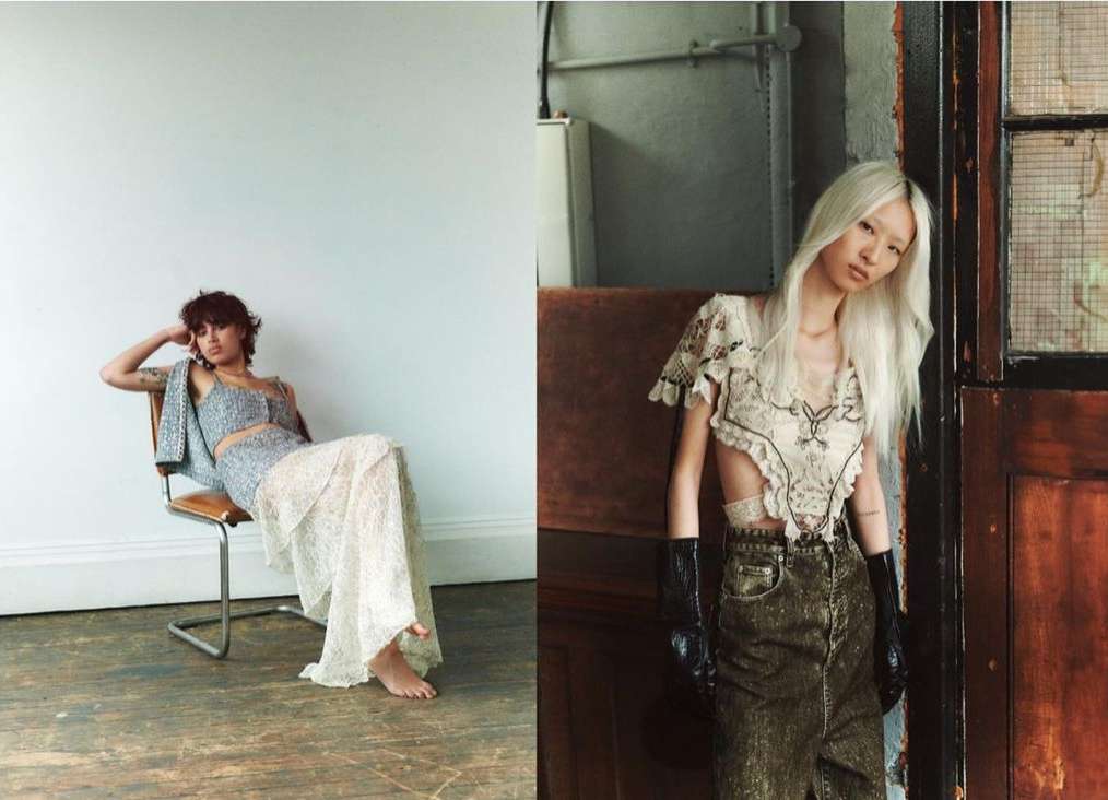 Two women pose indoors; one seated in a sequin top and skirt, the other standing with a lace top and dark wash jeans.