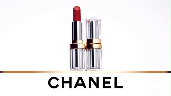 Two tubes of red lipstick on a gold bar, displayed on a white background with the name CHANEL in bold black letters.