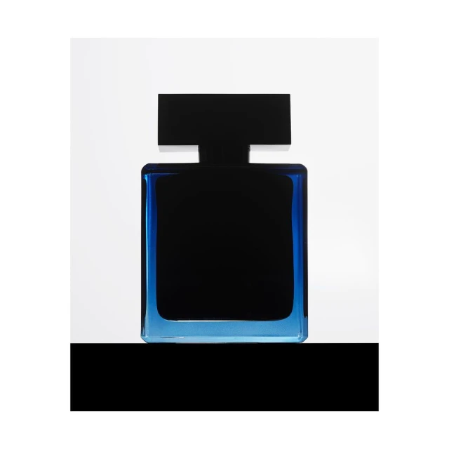 Elegant, squared perfume bottle featuring dark liquid enclosed by a transparent blue glass frame, set against a clean, white backdrop.