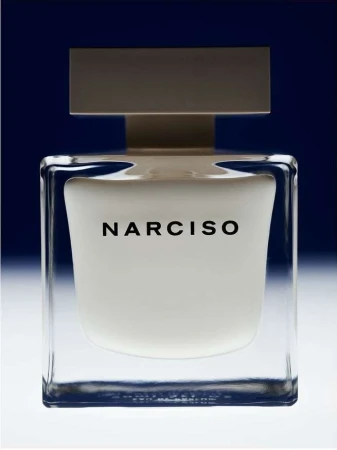 Narciso Rodriguez perfume bottle in clear glass with a white block, shot in studio with a dark gradient blue background.