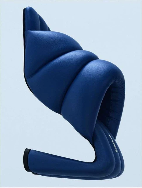 Studio shot of a blue chair with a unique design, featuring a padded seat and back, presented against a light blue gradient background.