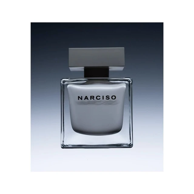 Close-up studio shot of a square glass Narciso Rodriguez perfume bottle with a gray cap, against a gradient gray background.