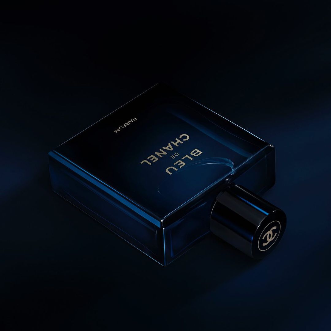 Close-up studio shot of a Bleu de Chanel parfum bottle, showcasing its dark blue glass and black cap with the Chanel logo.