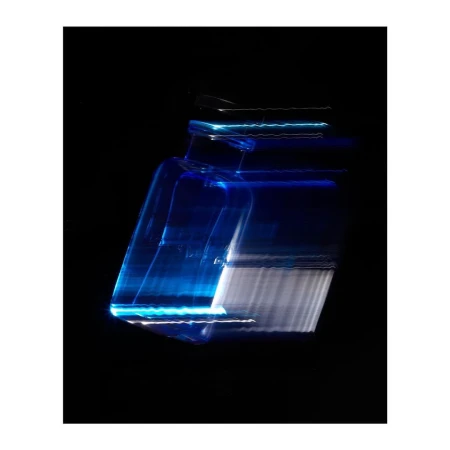 Abstract image of an illuminated blue glass bottle with blurred motion effect on a black background, creating a unique artistic effect.