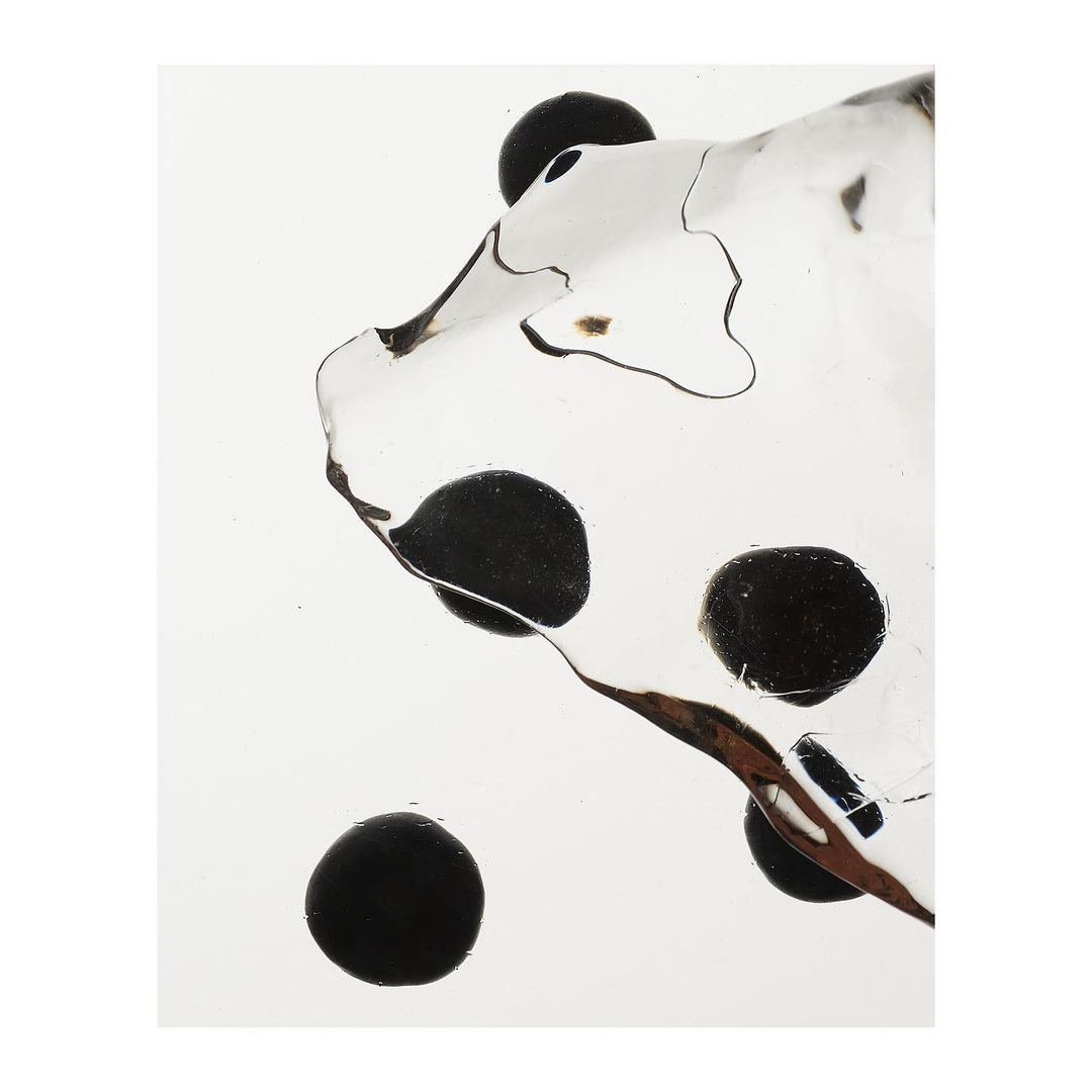 Close-up studio shot of a clear acrylic dice showing the pips through the transparent material, creating a minimalist geometric aesthetic.
