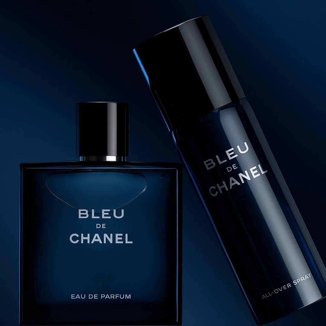 Close-up studio shot of Bleu de Chanel Eau de Parfum and All-Over Spray, both in sleek dark blue bottles with silver text labels.