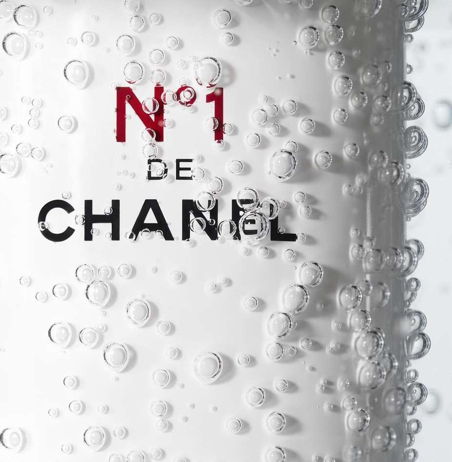 Chanel N°1 product label with black logo and red number. Bubbles surround the label, creating a fresh and clean aesthetic.