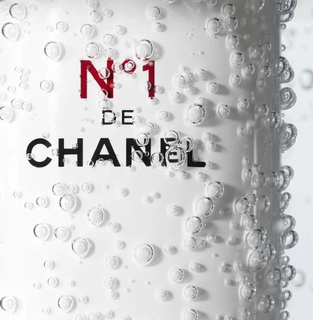 Chanel N°1 product label with black logo and red number. Bubbles surround the label, creating a fresh and clean aesthetic.