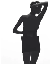 High-contrast silhouette of a short-haired woman wearing a wide metallic bracelet against a bright white background.