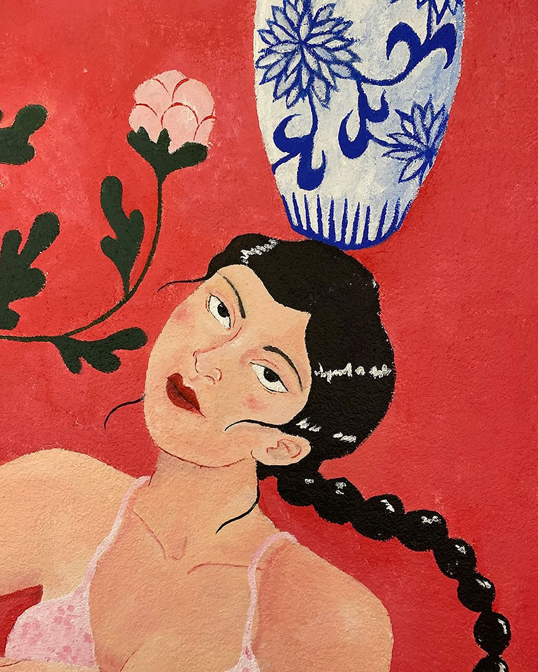 Illustration of a woman in a pink bra, with a black braid, alongside a flower and a blue and white vase, against a red background.