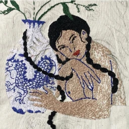Close-up embroidered textile art by Oriane Safre-proust depicting a woman with black braided hair next to a blue and white vase.