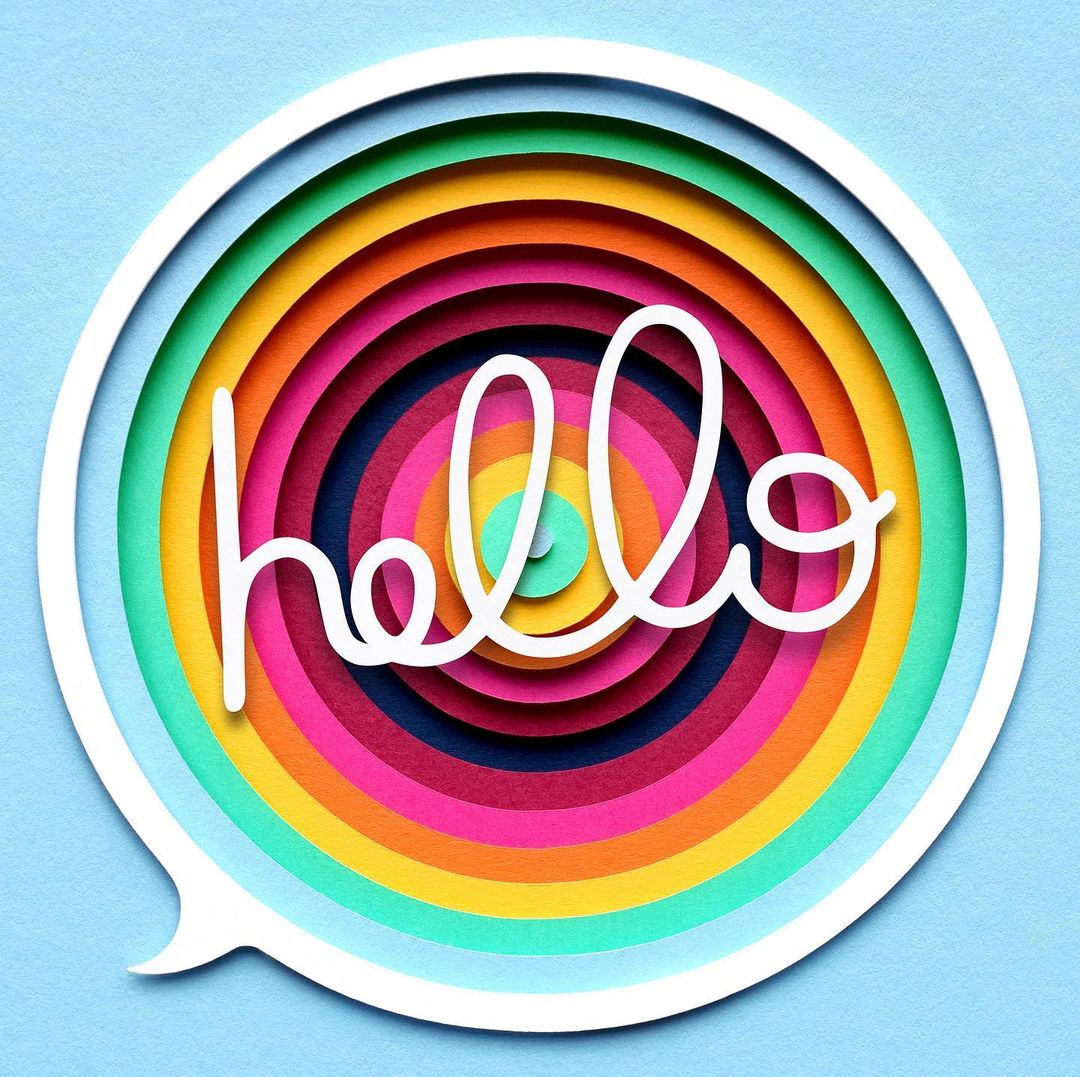 Paper art design featuring a speech bubble shape with rainbow concentric circles and the white cursive word 'hello' in the center.