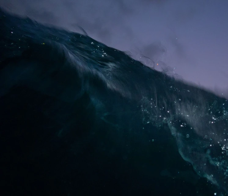Abstract ocean wave cresting, showcasing the interplay of deep blues, teals, and white highlights in a dynamic seascape composition.