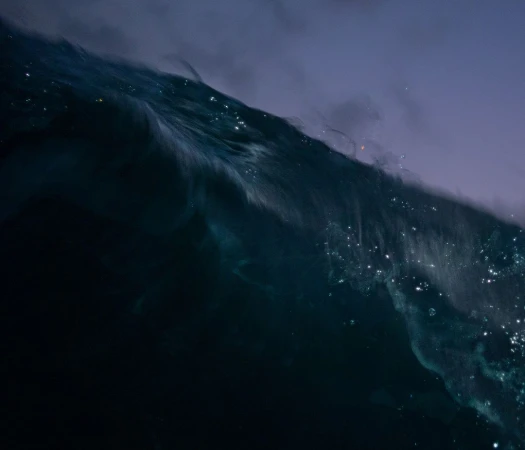 Abstract ocean wave cresting, showcasing the interplay of deep blues, teals, and white highlights in a dynamic seascape composition.