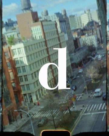 Aerial view of a city street with vintage color grading and a large letter overlay. Features buildings, traffic, and urban details.
