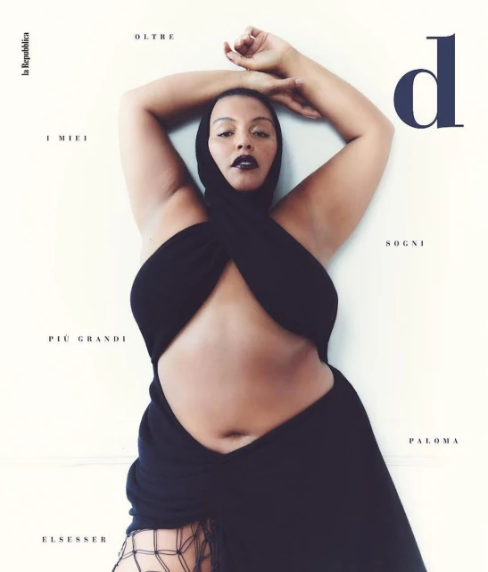 Fashion magazine cover featuring a plus-size model in a black dress and hood posing against a light background with editorial text.