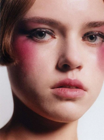 Close-up portrait of a young woman with heavy pink blush and winged eyeliner photographed by Pablo Freda