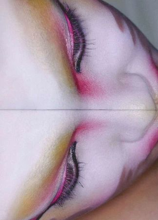 Close-up of a woman's face with pink and gold eye makeup, featuring long, dark eyelashes, captured with a soft, diffused lighting.