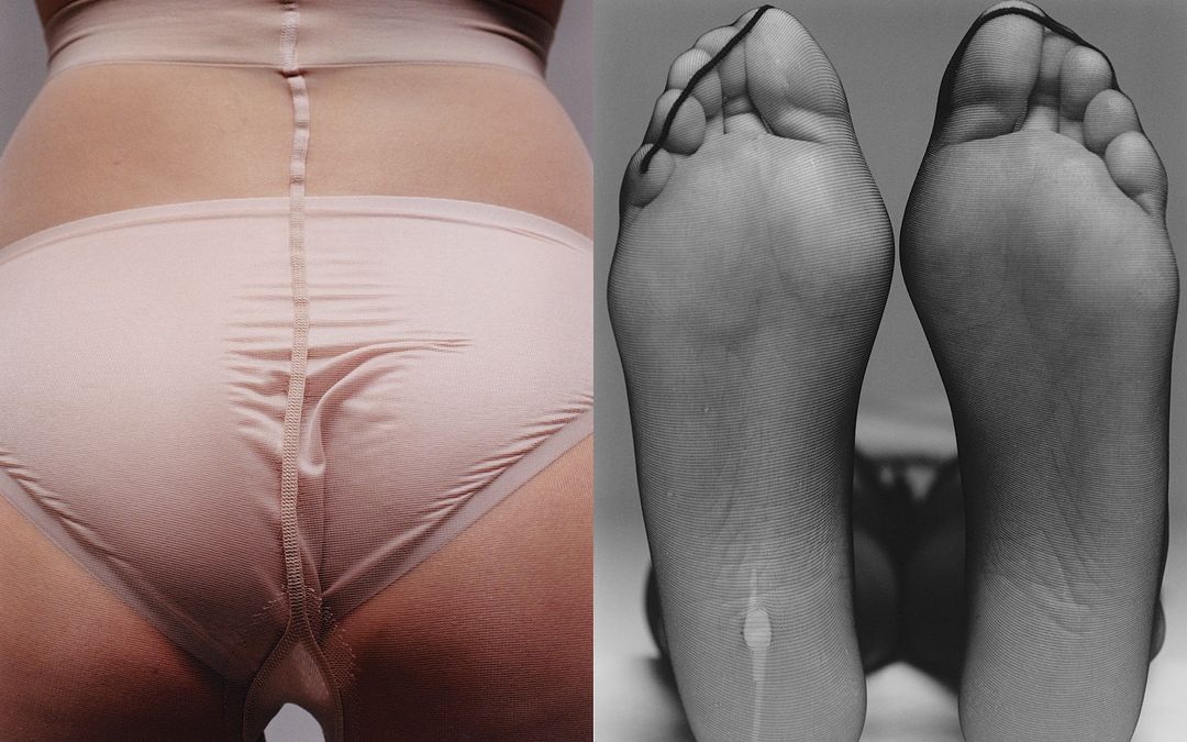 Close-up studio shot of a fair-skinned person's lower torso wearing light pink shapewear, with black pantyhose-covered feet to the right.