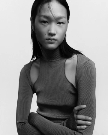Portrait of an East Asian woman wearing a ribbed turtleneck top against a plain light background photographed by Pablo Freda.