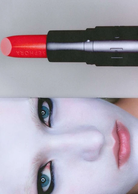 Close-up of SEPHORA brand lipstick in vibrant red tone, positioned above model's pale face with blue eyes, pink lips, and dark eye makeup.