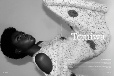 Black model wearing textured knitwear with dark circular patches lying on a plain background