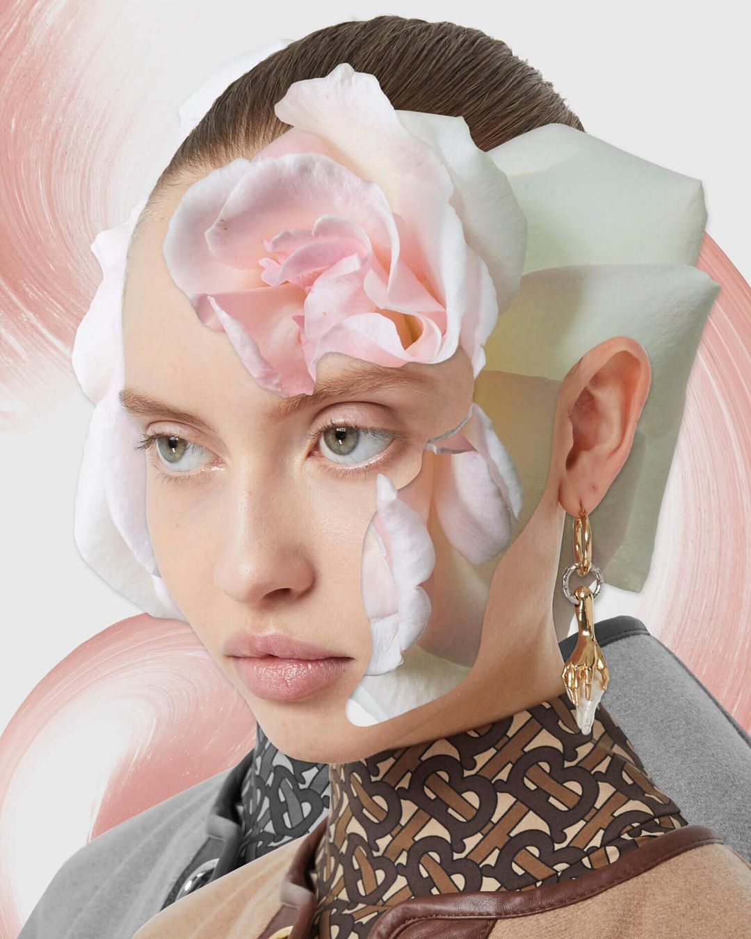 Portrait of a young woman with fair skin and light eyes, adorned with a soft pink rose and wearing a Burberry patterned top and earrings.