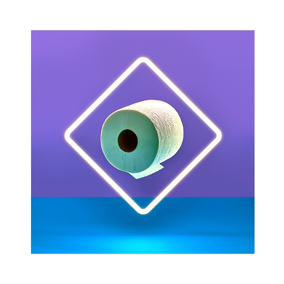 Still life of a roll of light-green toilet paper centered inside a white neon square over a blue and purple gradient backdrop.